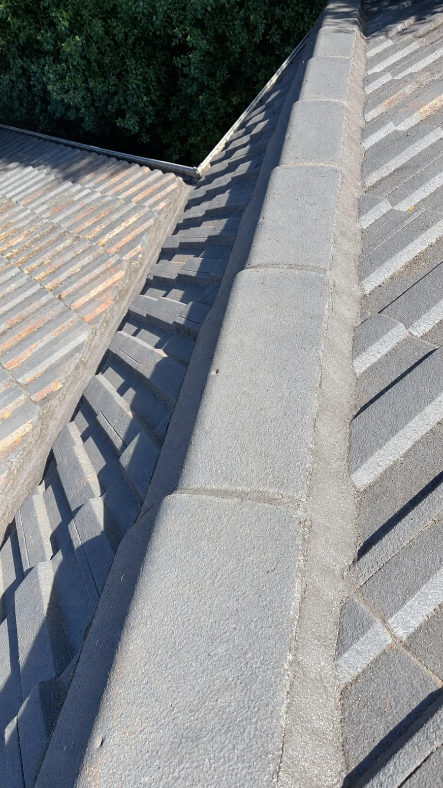 Matching view of the same tiled roof valley after clearing and ridge maintenance