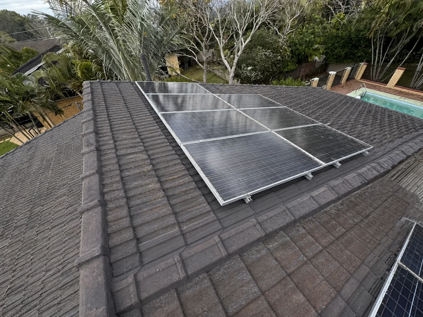 Matching roof-level view of the same tiled roof and solar array with tidier tiles and junctions